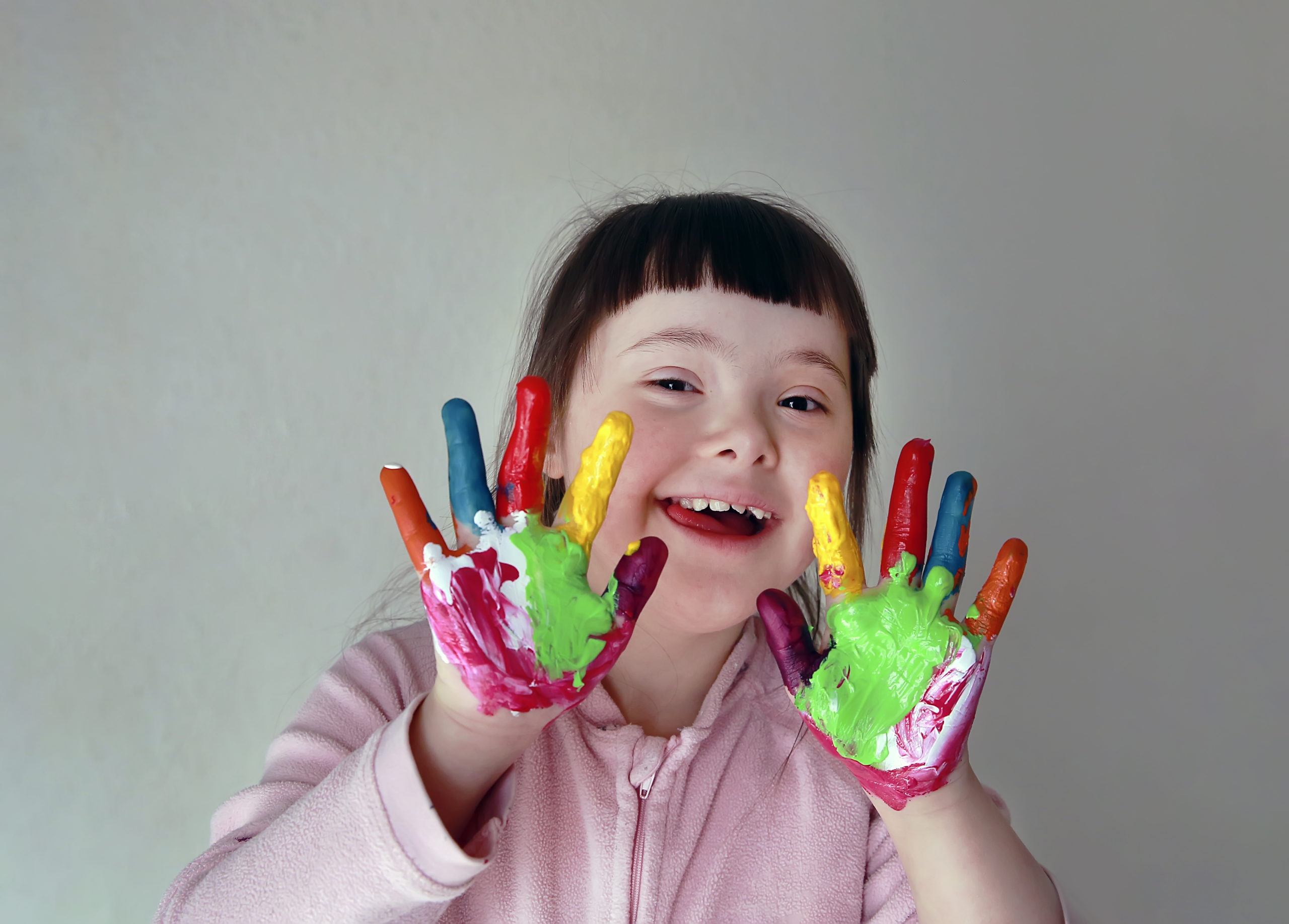 Little girl with painted hands. Isolated on grey background.